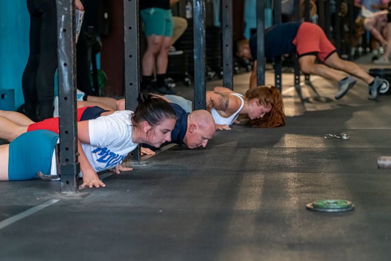 CrossFit Sabal Park members doing synchronized push-ups during a CrossFit Open workout